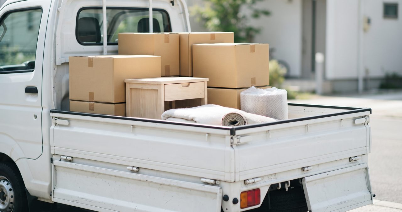 軽トラックの荷台に段ボール箱と小さな家具を積み終えた状態