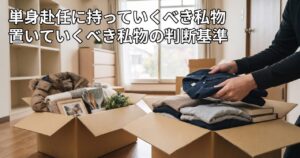 開いた段ボール箱に衣類や思い出の品を詰めながら持っていく私物を選んでいる様子